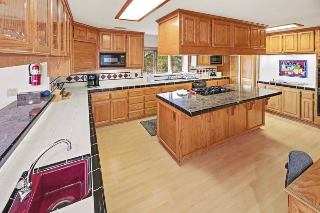 Bright wooden kitchen with central island and modern appliances.